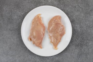 Beyaz seramik tabakta çiğ organik tavuk göğsü. Yüksek kalite fotoğraf