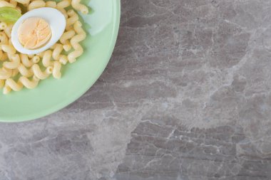 Yeşil tabakta dilimlenmiş yumurta ve makarna. Yüksek kalite fotoğraf