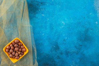 Fındık kabuğu kabuğunun içinde, tülün üzerinde, mavi arka planda. Yüksek kalite fotoğraf