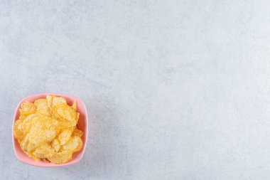 Taş zeminde pembe bir kase lezzetli çıtır patates kızartması. Yüksek kalite fotoğraf