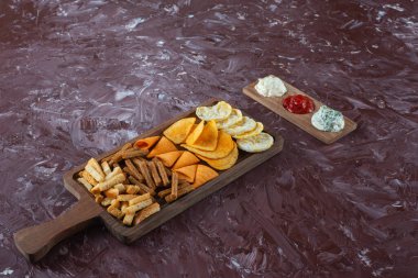 Mermer zemin üzerinde soslu çeşitli cipsler var. Yüksek kalite fotoğraf