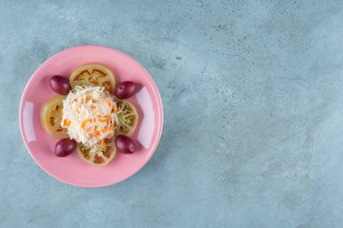 Mermer arka planda, bir tabakta mayalanmış sebzeler servis ediliyor. Yüksek kalite fotoğraf