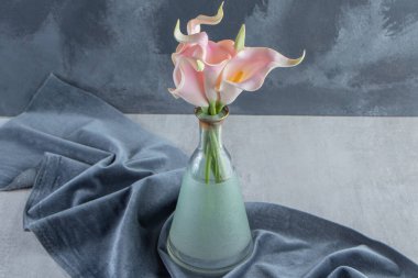 Kalla zambak bir parça kumaşın üzerinde, mermer arka planda. Yüksek kalite fotoğraf