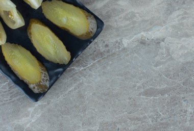 Siyah tabakta turşu dilimlerinin yakın fotoğrafını çek. Yüksek kalite fotoğraf