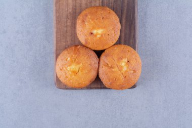 Tahta kesme tahtasının üzerinde üç tatlı kek. Yüksek kalite fotoğraf