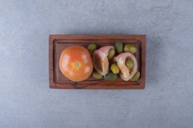 Kesme tahtasında çiğ zeytin ve domates, mermer arka planda. Yüksek kalite fotoğraf