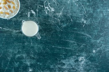 Kuru üzümler bir kase sütlü pudingin yanında, mavi arka planda. Yüksek kalite fotoğraf