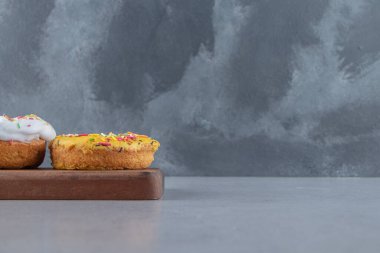 Tahtaya serpiştirilmiş beyaz ve sarı çörekler. Yüksek kalite fotoğraf