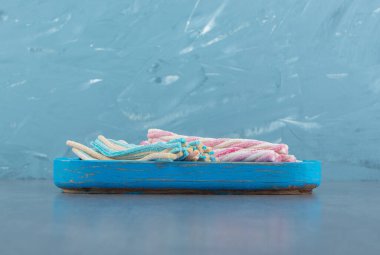 Mavi tabakta renkli bükülmüş şekerler. Yüksek kalite fotoğraf