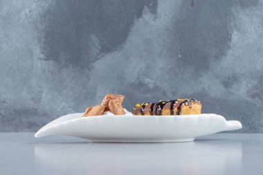 Lezzetli çikolatalı çörek ve yapraklı tabakta kremalı mısır gevreği. Yüksek kalite fotoğraf