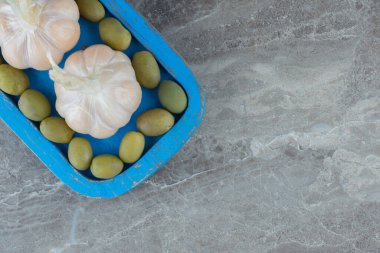 Mavi ahşap tabakta sarımsaklı yeşil zeytin manzarası. Yüksek kalite fotoğraf