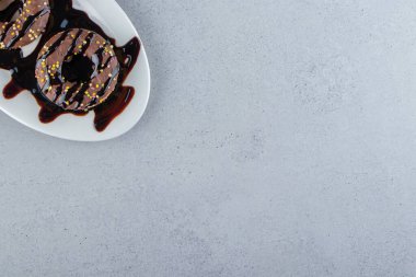 Taş zeminde beyaz bir tabak lezzetli çikolatalı çörek. Yüksek kalite fotoğraf