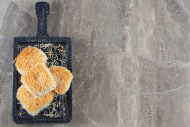 Lezzetli Türk tatlıları kadayif tahtada, mavi arka planda. Yüksek kalite fotoğraf