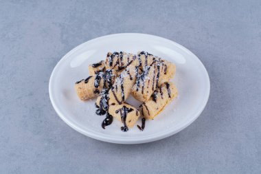 Üzerine çikolata sosu serpiştirilmiş beyaz bir tabak şeker. Yüksek kalite fotoğraf