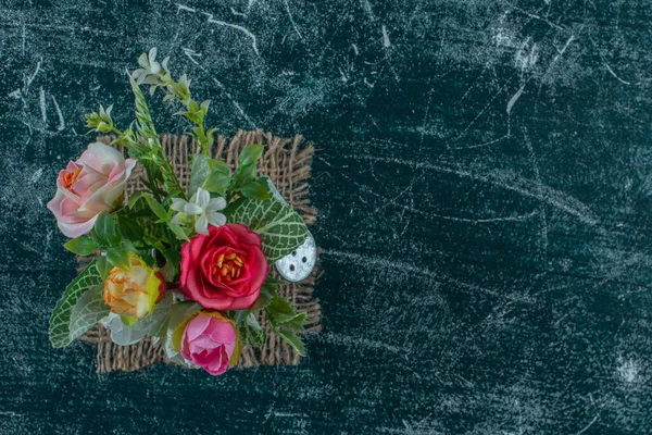 Mavi arka planda, sulama kutusunda suni çiçekler. Yüksek kalite fotoğraf