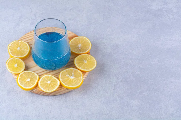 Нарізаний Лимон Поруч Склянкою Блакитної Смузі Дерев Яній Тарілці Мармуровому — стокове фото
