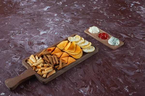 Mermer zemin üzerinde soslu çeşitli cipsler var. Yüksek kalite fotoğraf