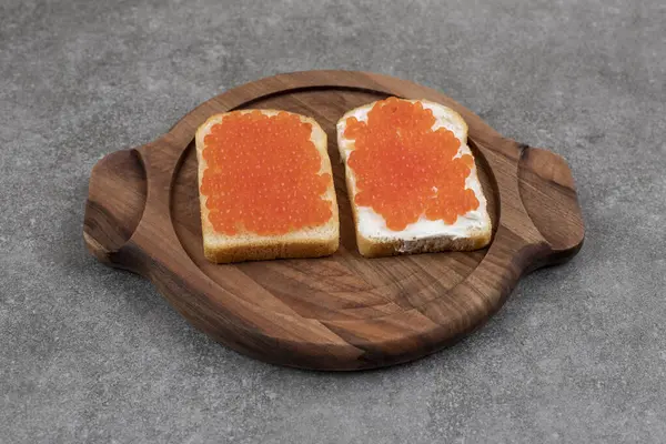 Tahta tahtada kırmızı havyarlı iki taze sandviç. Yüksek kalite fotoğraf
