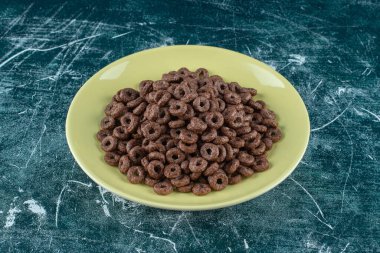 Mavi arka planda bir tabak çikolatalı mısır halkası. Yüksek kalite fotoğraf