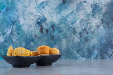 Mavi arka planda siyah kekler ve bisküviler. Yüksek kalite fotoğraf