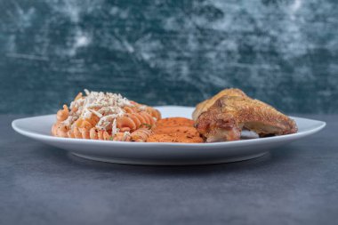 Lezzetli fusilli makarna ve beyaz tabakta tavuk kanadı. Yüksek kalite fotoğraf