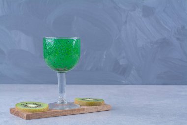 Misket arka planında dilimlenmiş kivi ve kivi suyu. Yüksek kalite fotoğraf