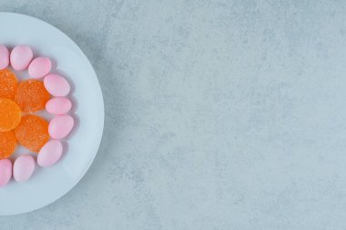 Bir tabak dolusu tatlı turuncu marmelat ve pembe şeker. Yüksek kalite fotoğraf