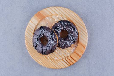 Tahta bir tabak lezzetli çikolatalı donut ve serpiştirilmiş. Yüksek kalite fotoğraf