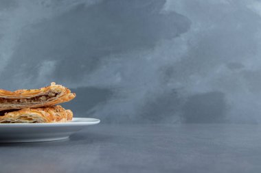 Beyaz tabakta etle doldurulmuş üçgen şekilli hamur işleri. Yüksek kalite fotoğraf