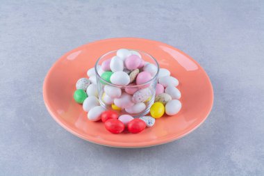 Gri arka planda bir bardak dolusu renkli fasulye şekeri. Yüksek kalite fotoğraf.