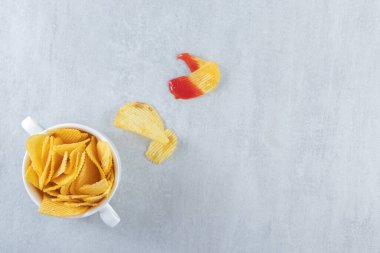 Beyaz kasede çıtır çıtır, lezzetli dalgalı cipsler. Yüksek kalite fotoğraf