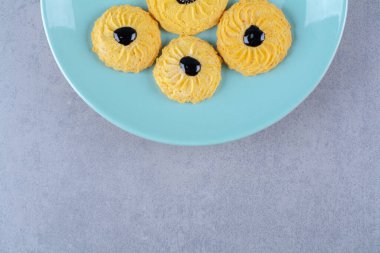 Mavi tabakta çikolata soslu lezzetli sarı kurabiyeler. Yüksek kalite fotoğraf