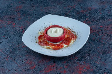 Baharatlı ve domates soslu mavi bir tabak yumurta. Yüksek kalite fotoğraf