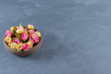 Beyaz arka planda, bir kasede renkli çiçekler. Yüksek kalite fotoğraf