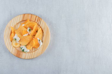 Tuzlu çıtır cips ve ahşap tabakta taze yoğurt. Yüksek kalite fotoğraf