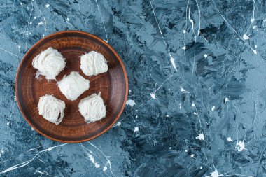 Geleneksel Türk pamuk şekeri ahşap bir tabakta, mavi arka planda. Yüksek kalite fotoğraf