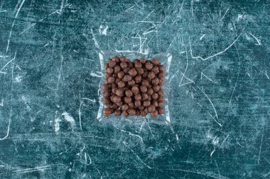 Mavi arka planda cam bir kasede tatlı mısır topları. Yüksek kalite fotoğraf