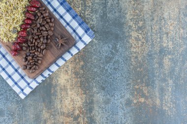 Kahve çekirdekleri, kurumuş gül kalçası ve tahta üzerinde çiçekler. Yüksek kalite fotoğraf