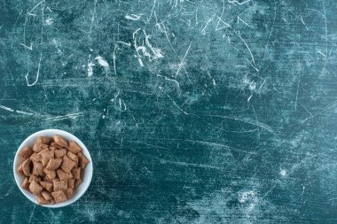 Mavi arka planda, bir kasedeki mısır yastıkları. Yüksek kalite fotoğraf