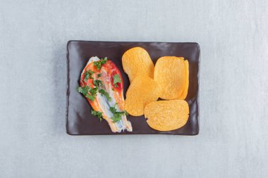 Çıtır cipsler, ketçap ve mayonezle birlikte koyu tabakta. Yüksek kalite fotoğraf