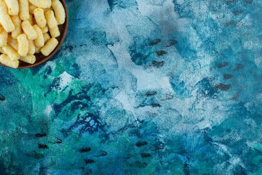 Mavi arka planda bir kase mısır çubuğu. Yüksek kalite fotoğraf