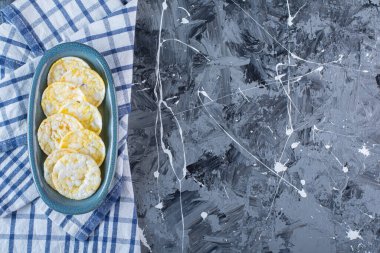 Çay havlusundaki tabakta patates cipsi, mermer arka planda. Yüksek kalite fotoğraf