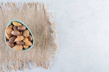 Taş zemin üzerinde kabuklu badem ve ceviz kasesi. Yüksek kalite fotoğraf