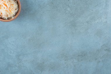 Mayalanmış lahana turşusu. Mavi arka planda, kilden bir kasede havuç var. Yüksek kalite fotoğraf