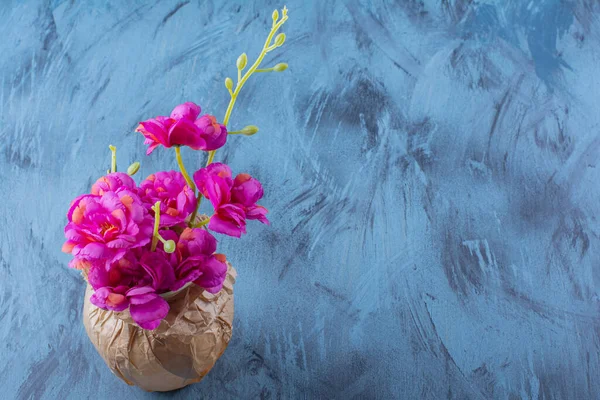 Papierowy Wazon Pięknymi Purpurowymi Kwiatami Niebieskim Tle Wysokiej Jakości Zdjęcie — Zdjęcie stockowe