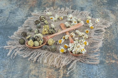 Kurumuş papatya çayı ve tahta kaşıklarla çuval bezinde diğer çiçekler. Yüksek kalite fotoğraf