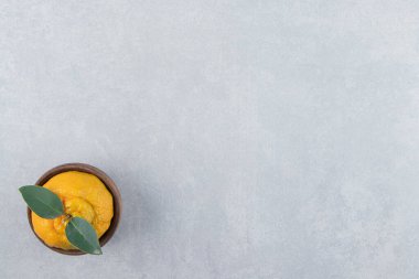 Tahta kasede yaprakları olan tek bir taze mandalina. Yüksek kalite fotoğraf