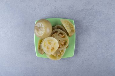 Mermer arka planda, tabakta çiğ domates turşusu. Yüksek kalite fotoğraf