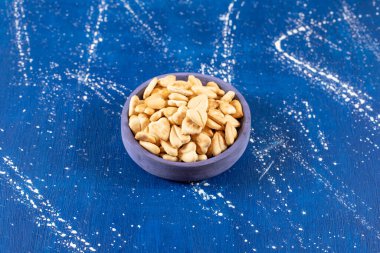 Mavi kaseye konmuş tuzlu kalp şeklinde kraker yığını. Yüksek kalite fotoğraf