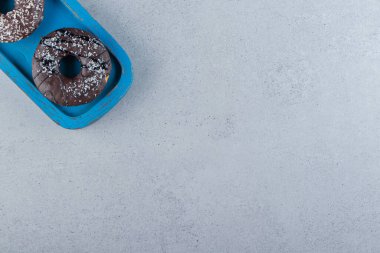 Taştan arka planda mavi bir tabak çikolatalı çörek. Yüksek kalite fotoğraf